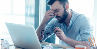 V stressed man holding his head in his hand